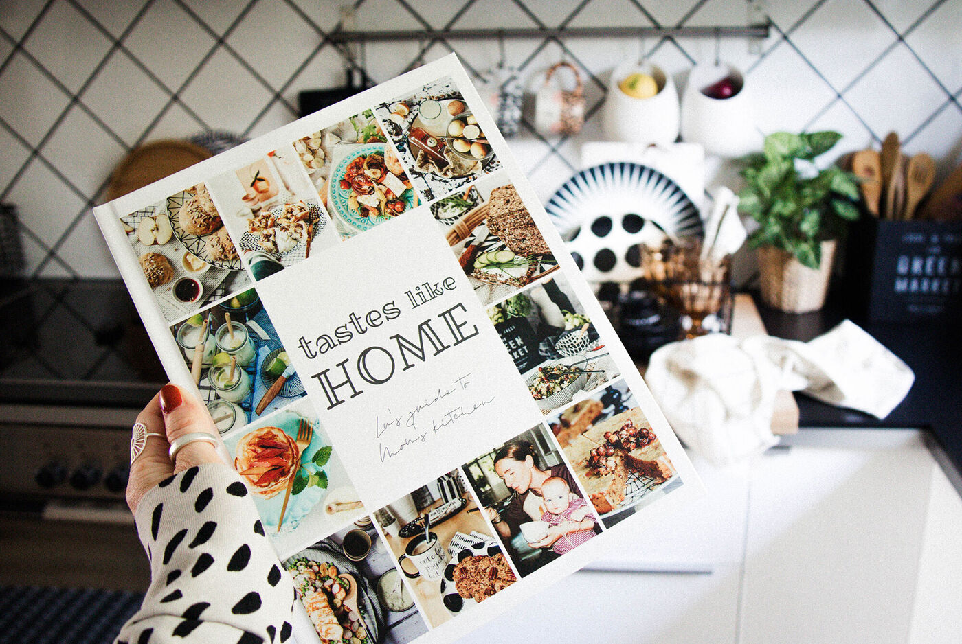 Eine Person hält ein kreatives Kochbuch mit vielen bunten Rezepten in der Küche. Das Buch zeigt Bilder von verschiedenen Gerichten und ist liebevoll gestaltet.