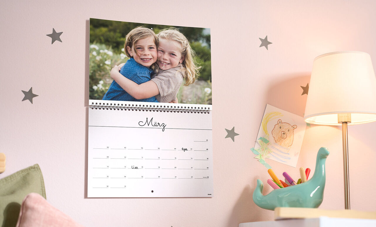 Ein liebevolles Foto von zwei Kindern, die sich umarmen, im CEWE Fotokalender für März